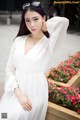 A woman in a white dress posing for a picture.