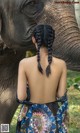 A woman standing next to an elephant in a field.