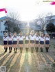 A group of girls in school uniforms posing for a picture.