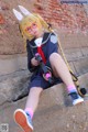 A girl in a school uniform holding a toy gun.